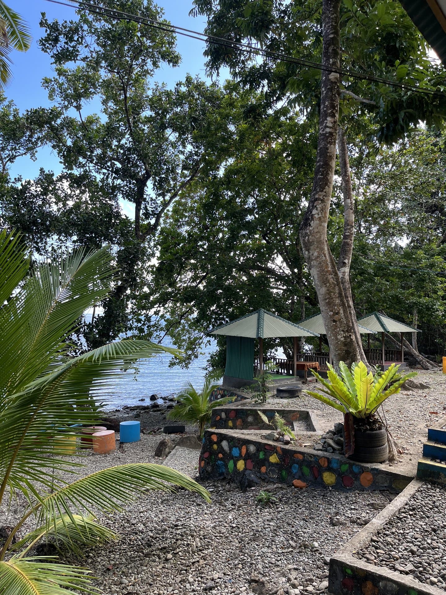 Gazebo-gazebo tepi laut di Shafira Resort dengan taman batu warna-warni