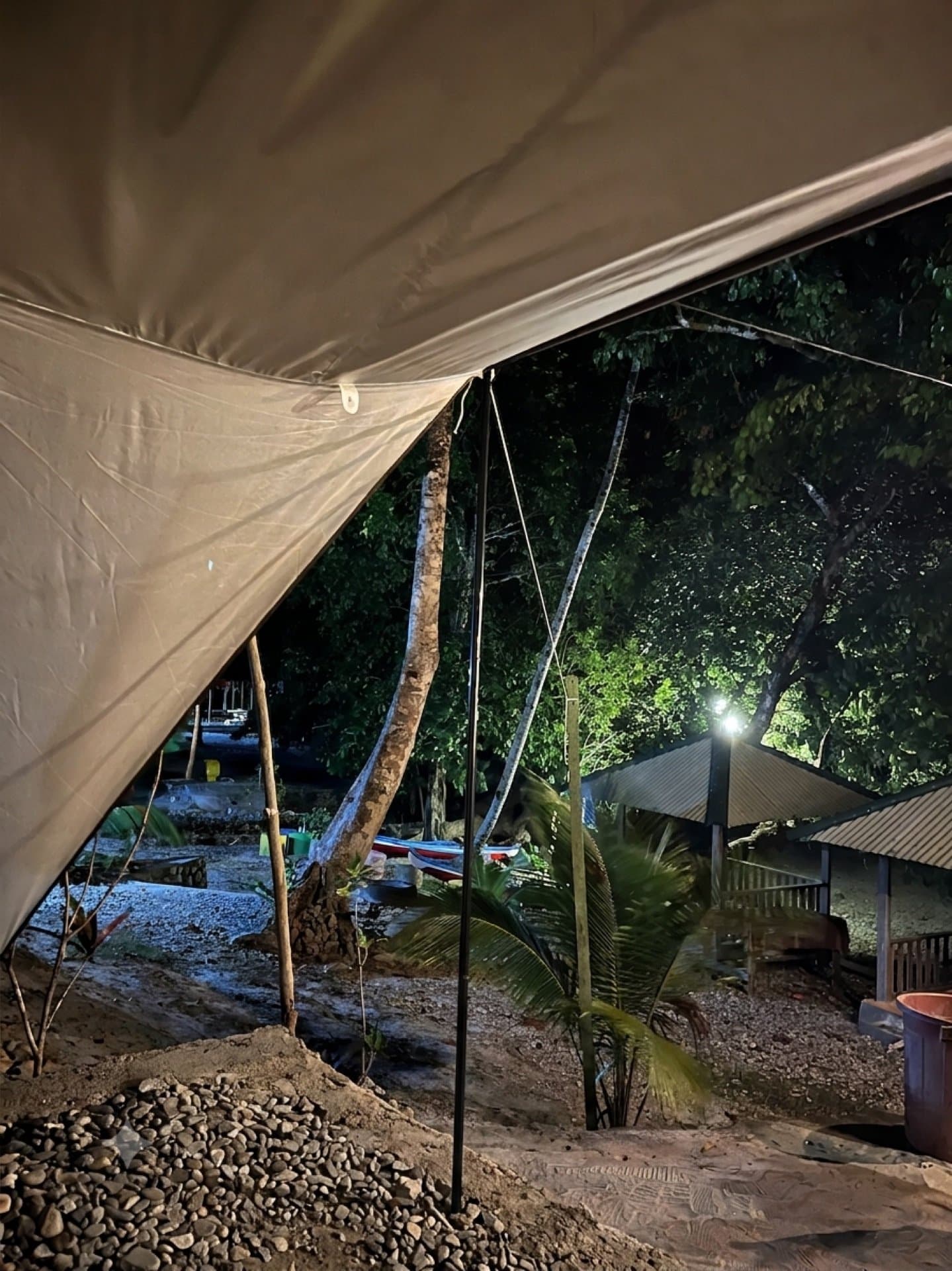 Tenda glamping Shafira Resort pada malam hari dengan latar pepohonan dan gazebo tepi pantai