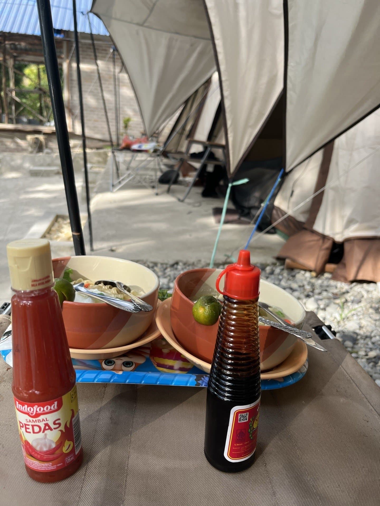Sajian mi kuah hangat dan sambal di area glamping Shafira Resort tepi pantai