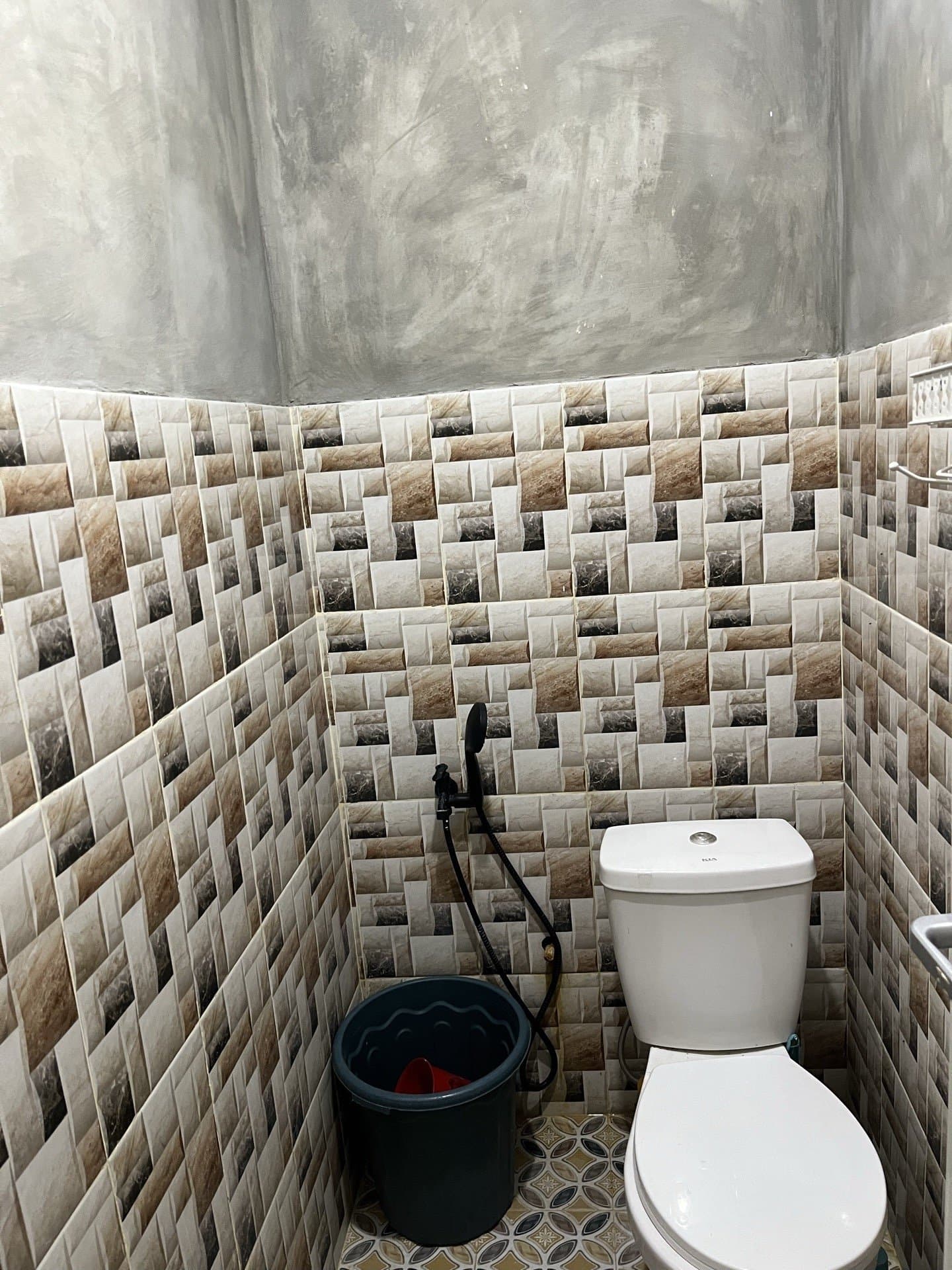 Kamar mandi dalam kamar Shafira Resort dengan kloset duduk dan dinding berkeramik