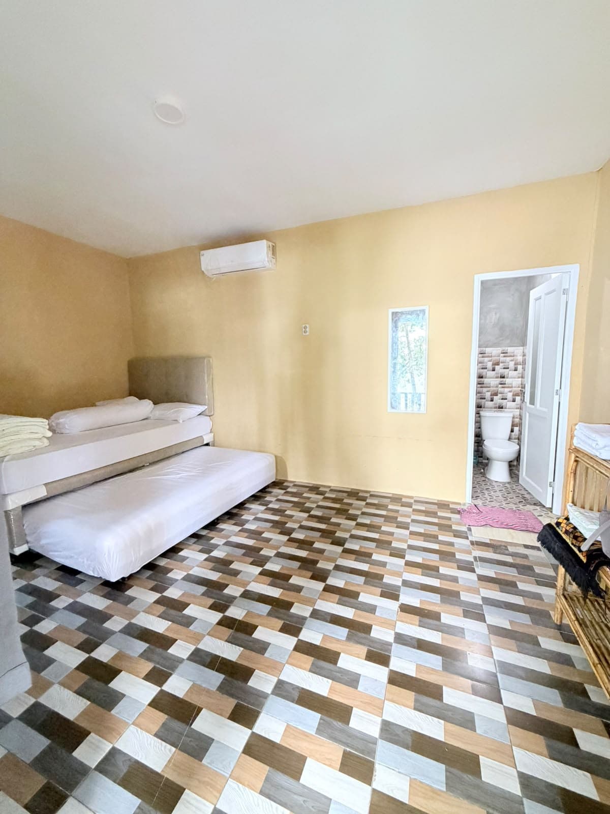 Kamar Shafira Resort ber-AC dengan ranjang sorong dua kasur dan lantai keramik motif