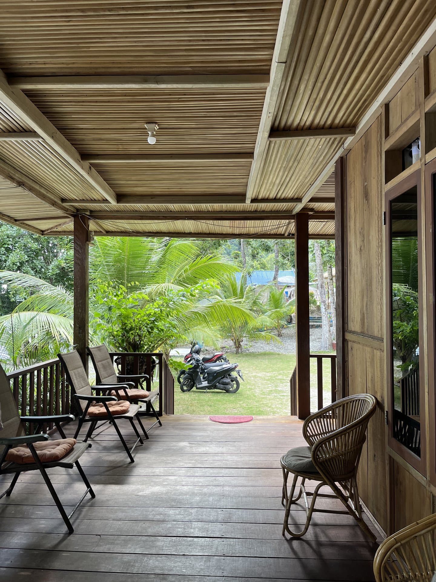 Grand Villa veranda at Shafira Resort with lounge chairs facing the coconut garden